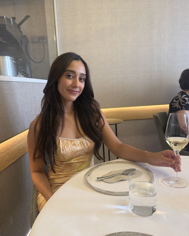 A guest at the table with a glass of white