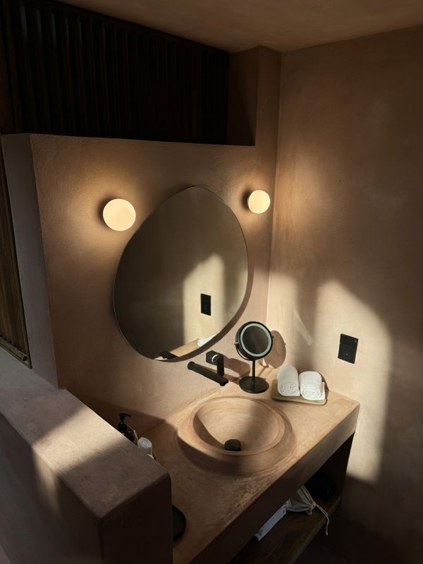 Stone sink and round mirror in warm light