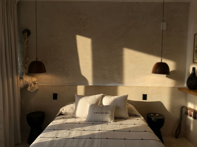 Bed against warm plaster with shadow play